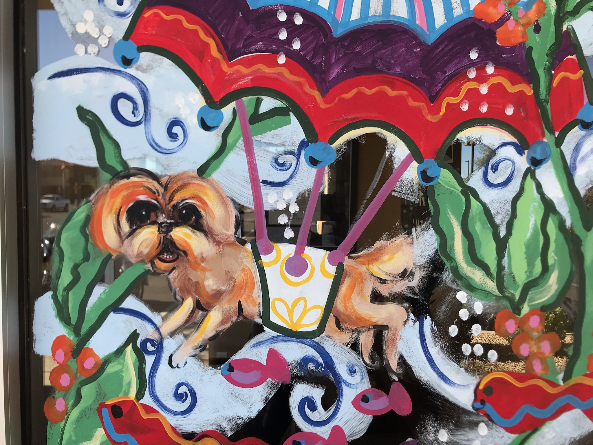 A storefront window hand-painted with a vibrant seasonal design